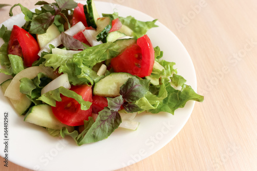  Salad with cucumbers, tomatoes, salad, pepper and basil. Home made food. Concept for a tasty and healthy meal.