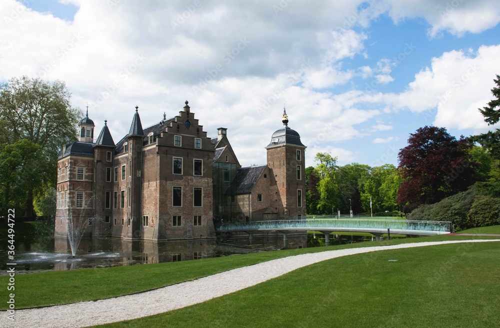 Historic castle with glass bridge and towers in a park with trees in the background. 16th century dutch architecture. Famous landmarks of the netherlands. 