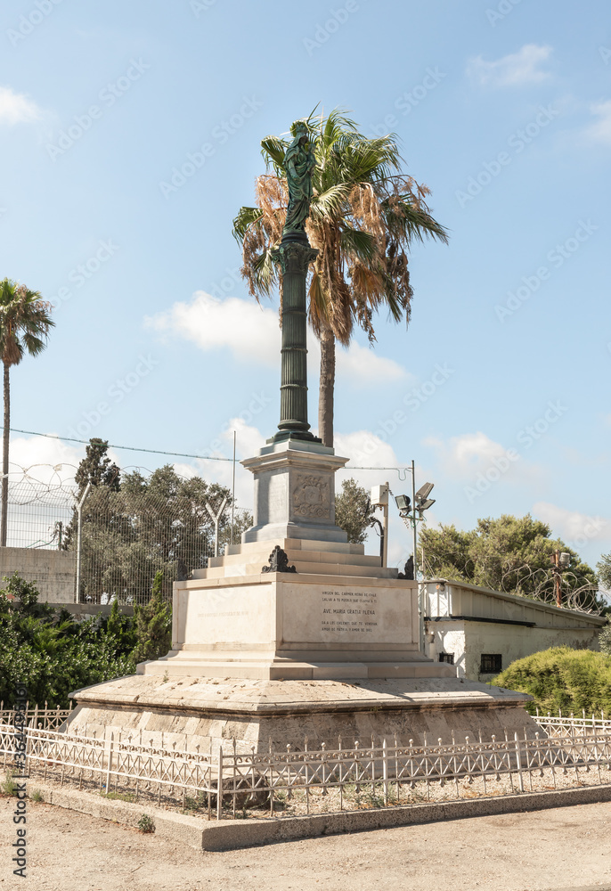 Obraz premium The statue of the Virgin Mary with a baby in her arms stands on a high pedestal opposite the Stella Maris Monastery which is located on Mount Carmel in Haifa city in northern Israel