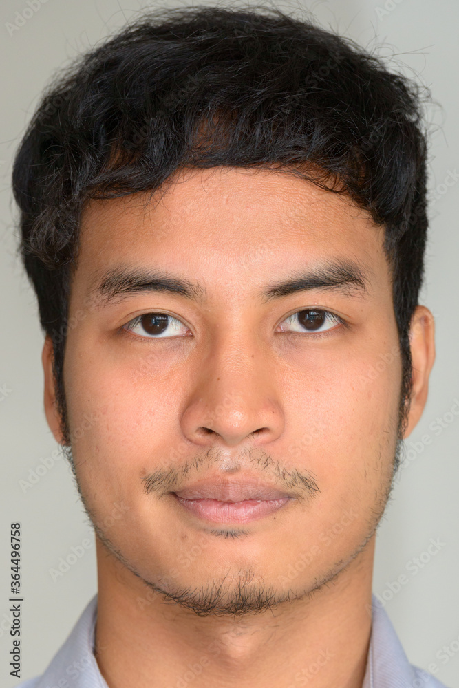 Face of young Asian businessman looking at camera Face of young Asian businessman looking at camera
