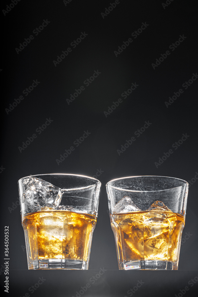 Glass of whisky on black background, copy space