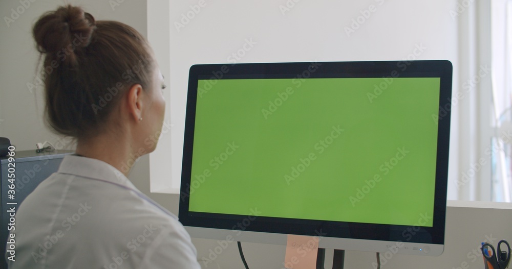 physician work on computer with green mockup screen physician work on computer with green mockup screen