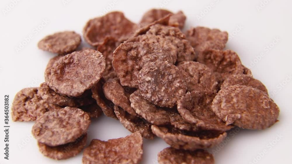 Rotating of chocolate cornflakes on white background. Side view, close up, macro. Rotating of chocolate cornflakes on white background. Side view, close up, macro.