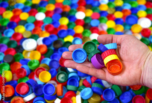 Plastic bottle caps background. Waste cap material is recyclable. Plastic lids from HDPE for recycle. Recycling plastic bottle caps.