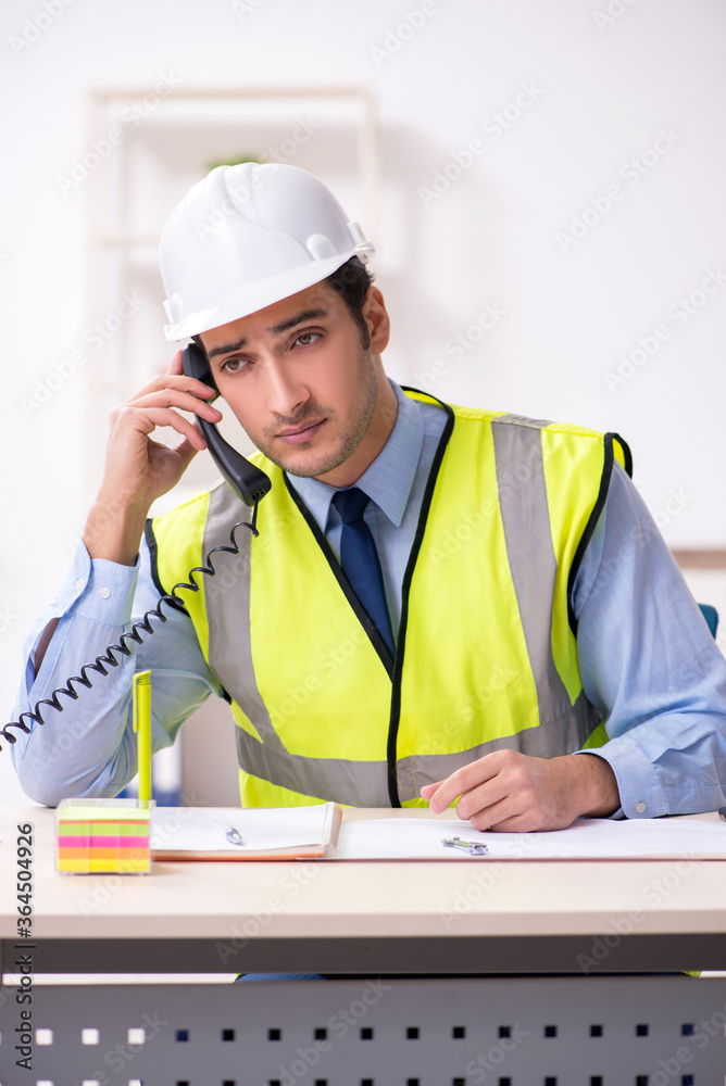 Young male architect working in the office Young male architect working in the office