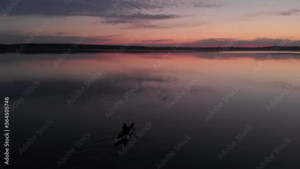 AERIAL Mid 50s Caucasian male canoeing on a traditional wooden boat on a large lake early in the morning. 4K UHD sunset shot AERIAL Mid 50s Caucasian male canoeing on a traditional wooden boat on a large lake early in the morning. 4K UHD sunset shot
