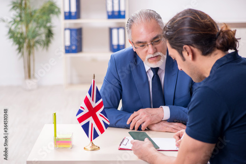 Young man visiting embassy for visa application photo