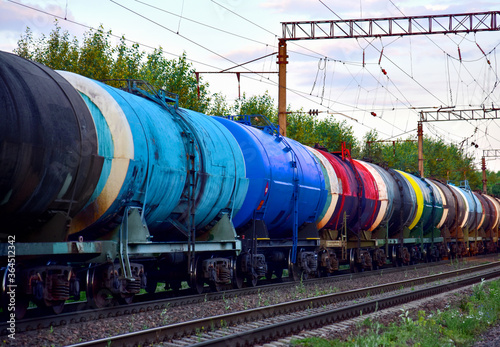 Freight train with petroleum tank cars on railroad. Rail cars carry oil and ethanol. Railway logistics explosive cargo. Transportation of methanol, crude and gas. Petrochemical tank cars. Out of focus