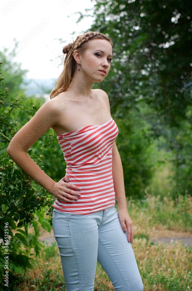 The beautiful girl is walking outdoors. Girl in the park. Girl on nature. Woman outside. Positive woman smiling The beautiful girl is walking outdoors. Girl in the park. Girl on nature. Woman outside. Positive woman smiling