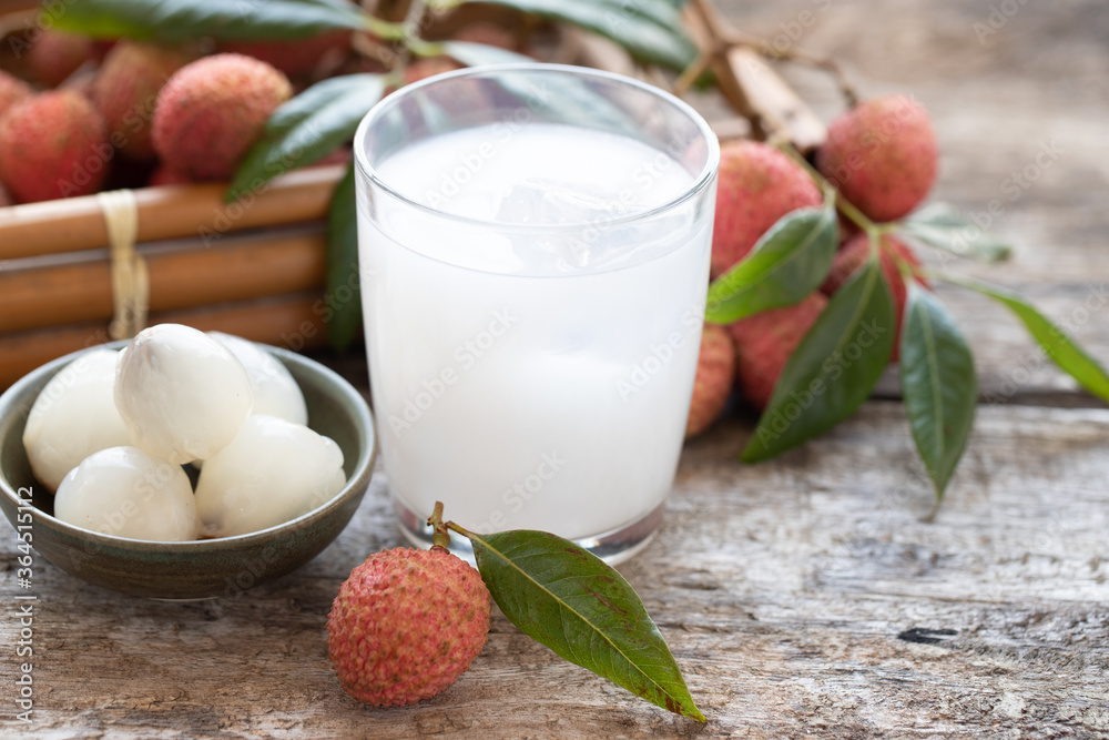 Φωτογραφία Sweet lychee juice on the wooden rustic background Closeup of fresh lychee juice with fruits