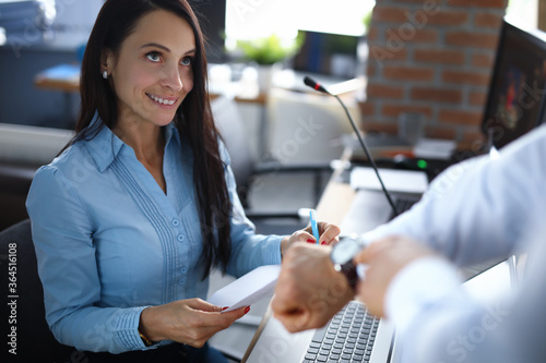 Woman in office with documents is shown on time. Workflow analytics concept photo