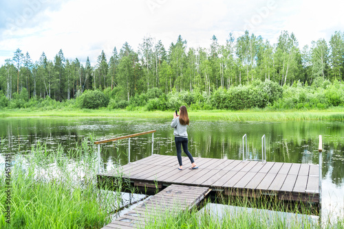 girl using smart phone by the lake in the forest © mdbildes