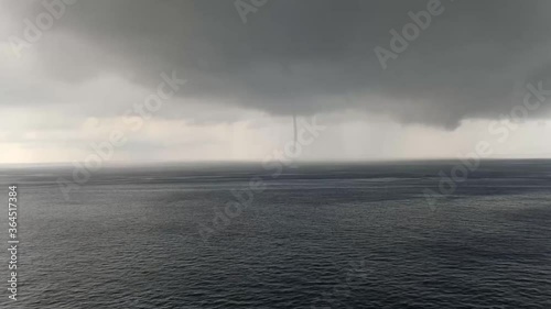 waterspout in ocean and cloudy sky photo