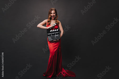 Fotografie, Obraz Full length portrait of red long dress holding clapperboard