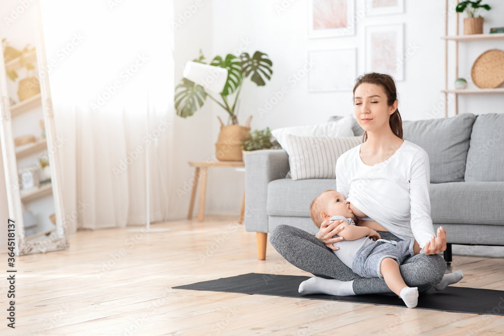 Relaxed Young Mother Meditating While Breastfeeding Her Baby At Home, Practicing Yoga