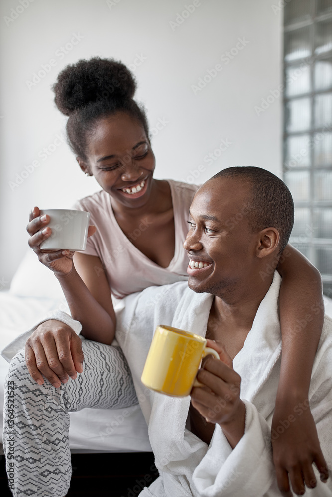 portrait of happy smiling married african couple in the morning at home, man and woman happy together, they are in love. posing at camera portrait of happy smiling married african couple in the morning at home, man and woman happy together, they are in love. posing at camera