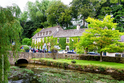 BIBURY, ENGLAND - SEPTEMBER 4, 2016: Old style city of Bibury in The Cotswolds know as Area Of Outstanding Beauty (AONB), England, United Kingdom, Europe photo