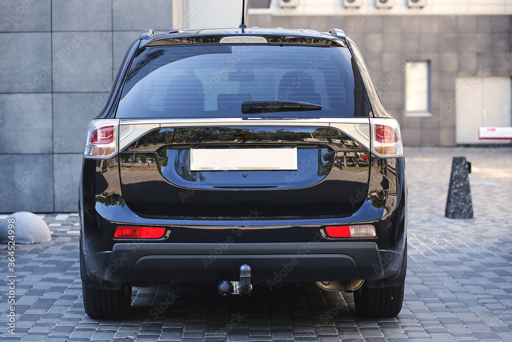 Back window of black car parked on the street in summer sunny day, rear view. Mock-up for sticker or decals Back window of black car parked on the street in summer sunny day, rear view. Mock-up for sticker or decals