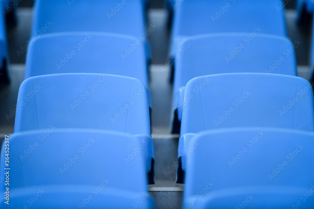 Fototapeta premium Empty soccer stadium tribune. As a safety measure during corona virus pandemic, soccer matches are taking place without public