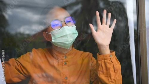 Asian girl wearing glasses, wearing a mask, holding paper labeled #stayhome, is bored of having to detain and treat the illness at home alone. Concept  prevention COVID-19