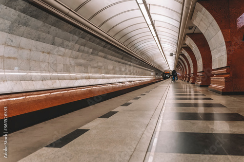 Long platform of underground, station interior. Abstract perspective view, lonely people