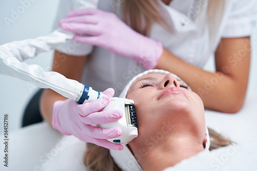 Adult woman in beauty salon undergoing face hydrogen purification