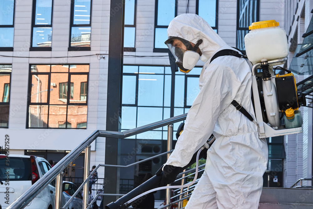 young disinfector in hazard suit conducts disinfection in contaminated area. professional disinfection against COVID-19. in clothing protecting from chemical poisoning in the industry