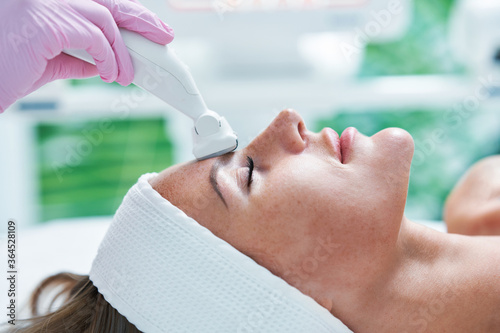 Konstfotografi Adult woman in beauty salon undergoing face hydrogen purification