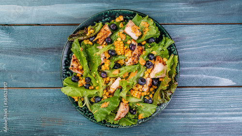 Fresh Tasty blueberries salad with chicken fillet, green vegetables and mustard. healthy food. banner, catering menu recipe place for text, top view