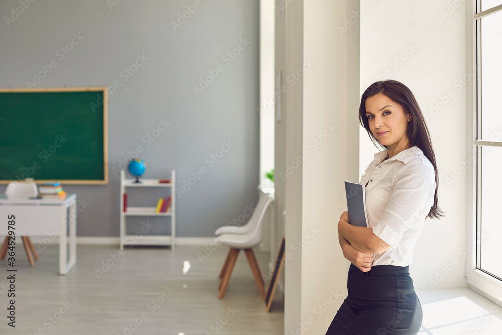Teacher with a book in his hand standing in class. Teacher with a book in his hand standing in class.