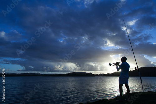 silhouette of a fisherman on a sunset background
