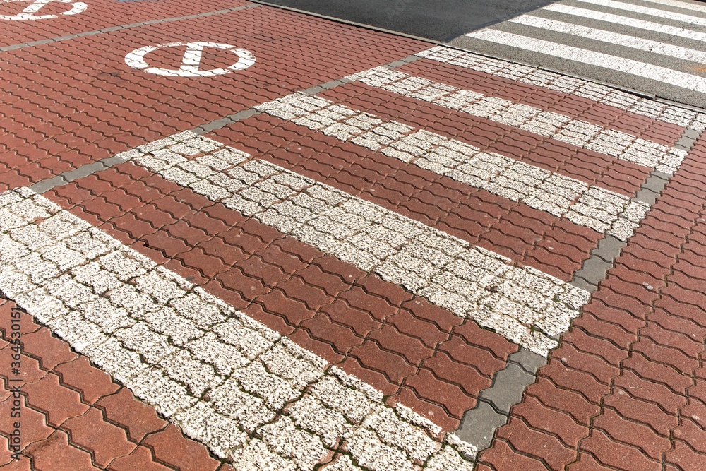 Crosswalk. Red concrete paving stones. Safe road crossing. Traffic signs.
