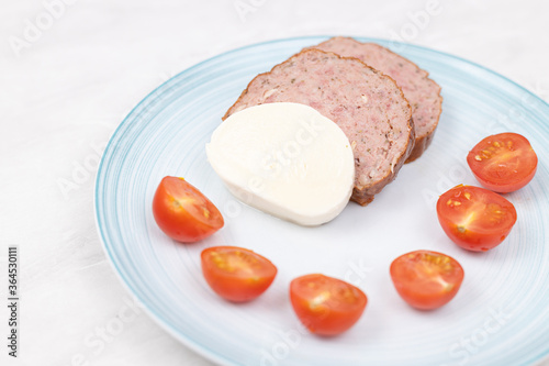 Sliced Meatloaf served with cheese and cherry tomatoes