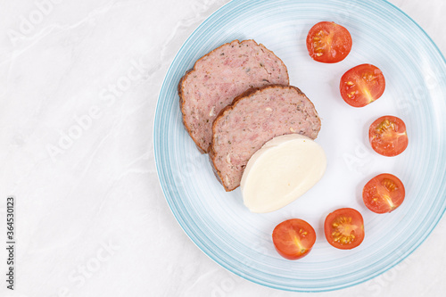 Sliced Meatloaf served with cheese and cherry tomatoes