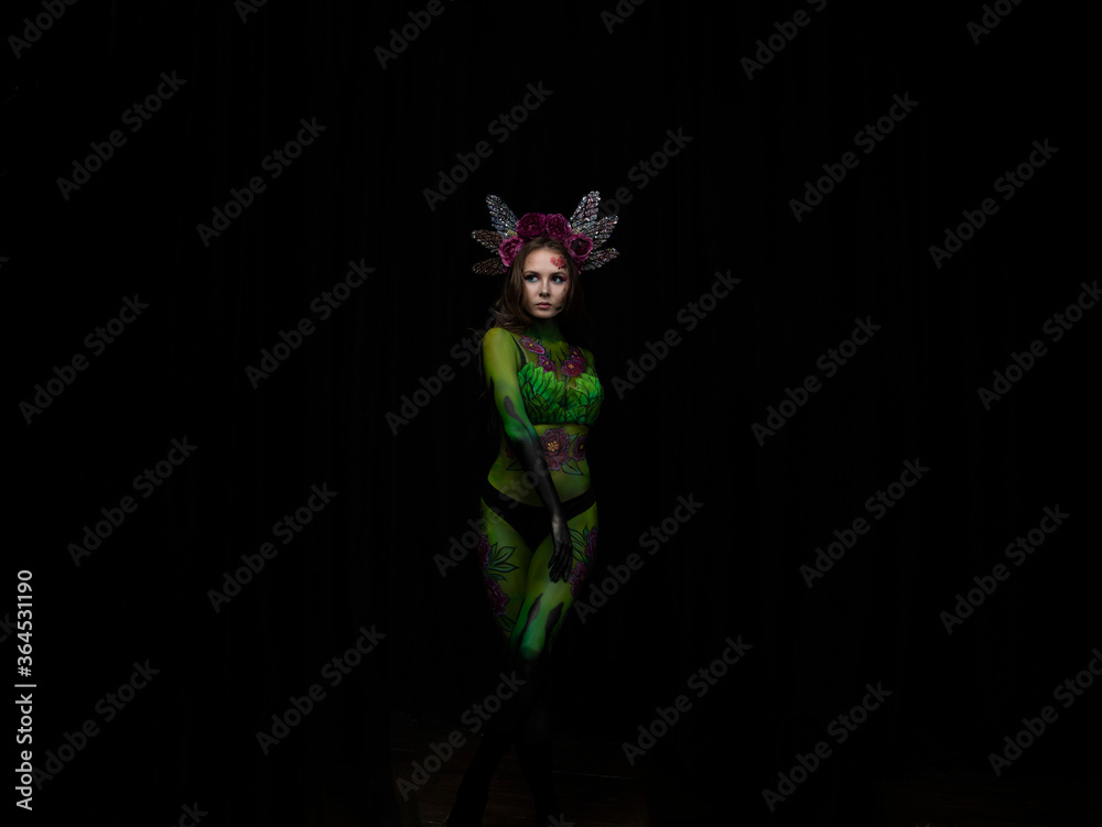 beautiful girl painted with green paint and flowers on her face and burgundy peonies in her body posing in different poses beautiful girl painted with green paint and flowers on her face and burgundy peonies in her body posing in different poses