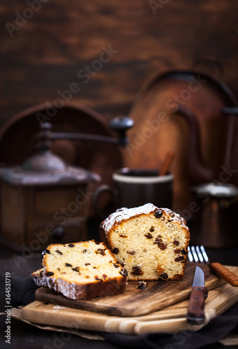 Delicious homemade cottage cheese and raisins loaf cake on dark rustic wooden background