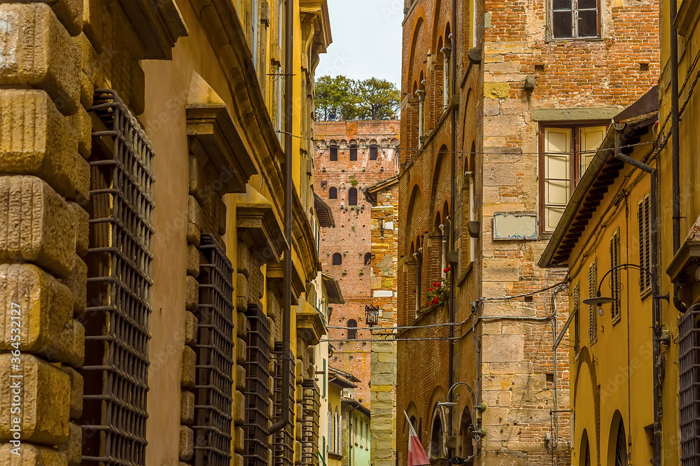 A view along the fortified streets towards the Guinigi Tower in Lucca, Italy in summer