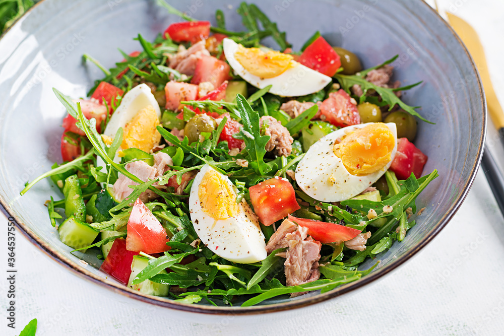 Healthy food. Tuna fish salad with eggs, cucumber, tomatoes, olives and arugula. French cuisine. Healthy food. Tuna fish salad with eggs, cucumber, tomatoes, olives and arugula. French cuisine.
