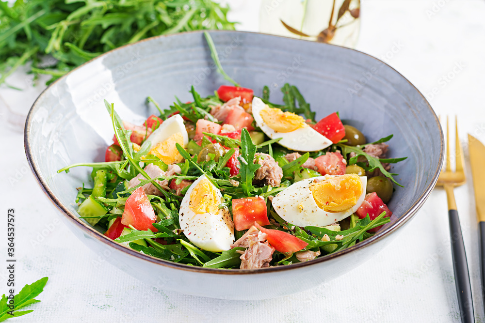 Healthy food. Tuna fish salad with eggs, cucumber, tomatoes, olives and arugula.  French cuisine.