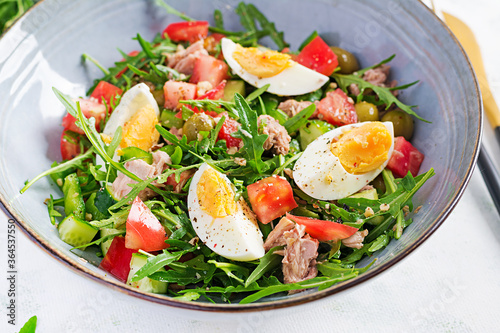 Healthy food. Tuna fish salad with eggs, cucumber, tomatoes, olives and arugula. French cuisine.