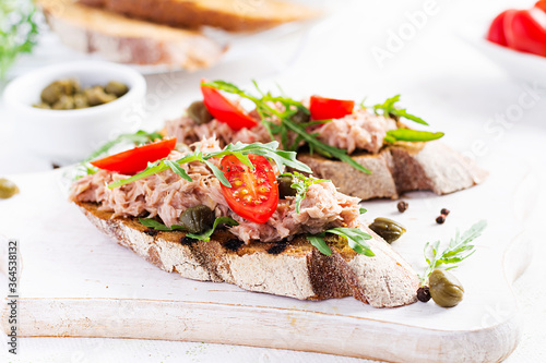 Toasts with tuna. Italian bruschetta sandwiches with canned tuna, tomatoes and capers.