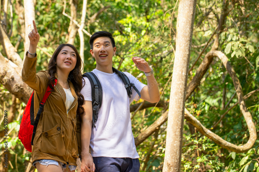 Asian traveler  couple holding hands each other walking in natural park enjoy view