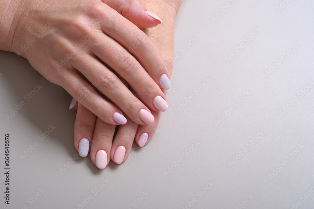 Stylish trendy manicure nail adult woman hands on a grey background, top view. Selective focus Stylish trendy manicure nail adult woman hands on a grey background, top view. Selective focus