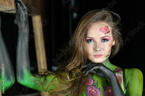 beautiful girl with flowers on her face and painted with burgundy peonies posing in different poses on a black background