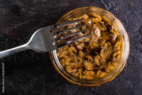 Glass jar of sprots with a fork on a concrete background photo