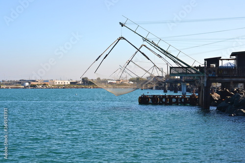 big fisher crane with nets in harbor at fiumicino italy photo