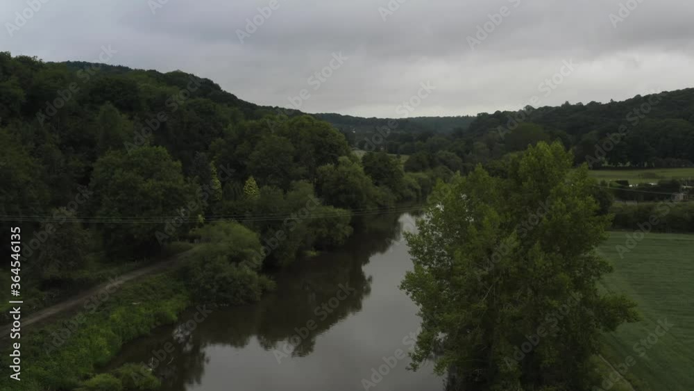 Overcast river scene rising aerial shot in UK countryside Overcast river scene rising aerial shot in UK countryside