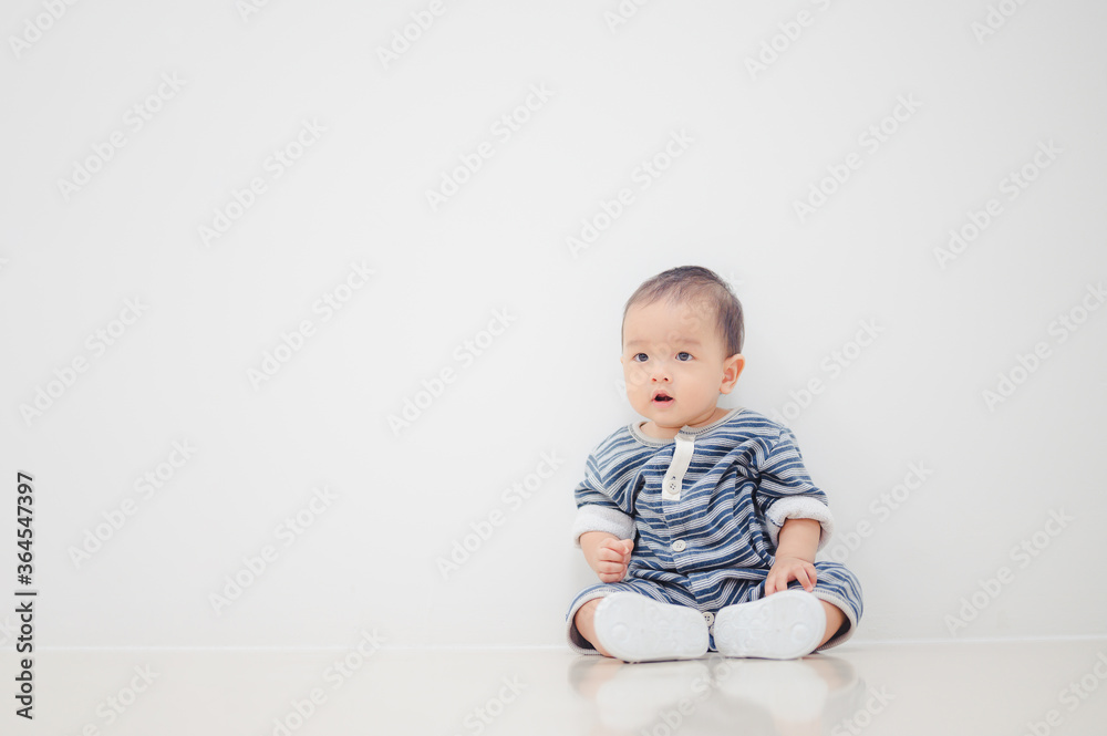 Smiling sitting asian baby boy at home on floor with white background. Smiling sitting asian baby boy at home on floor with white background.