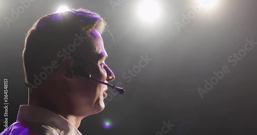 Man speaker says countdown in microphone preparing for starting show on stage. Stand up comedian waiting performance, concert. Actor playing role in theatre. Coach, Professor, scientist at conference. photo