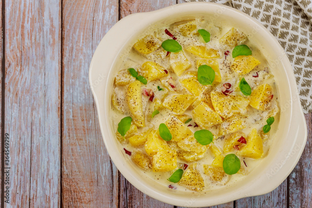 Roasted potatoes in oven bowl with creamy sauce.